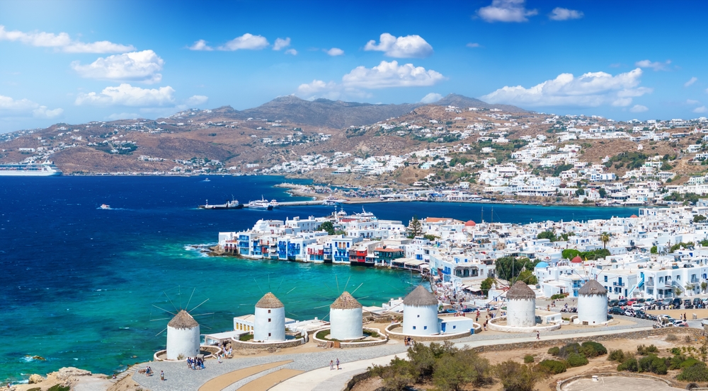 Utsikt gjennom vindmøllene over Mykonos by og Little Venice