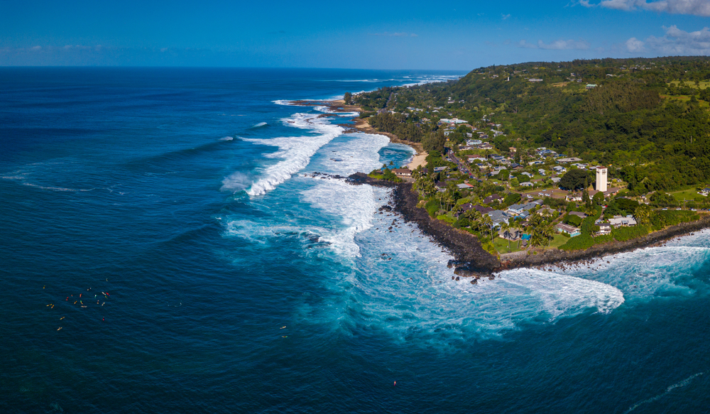 Flyfoto av North Shore på Oahu med surfere ved Waimea Bay