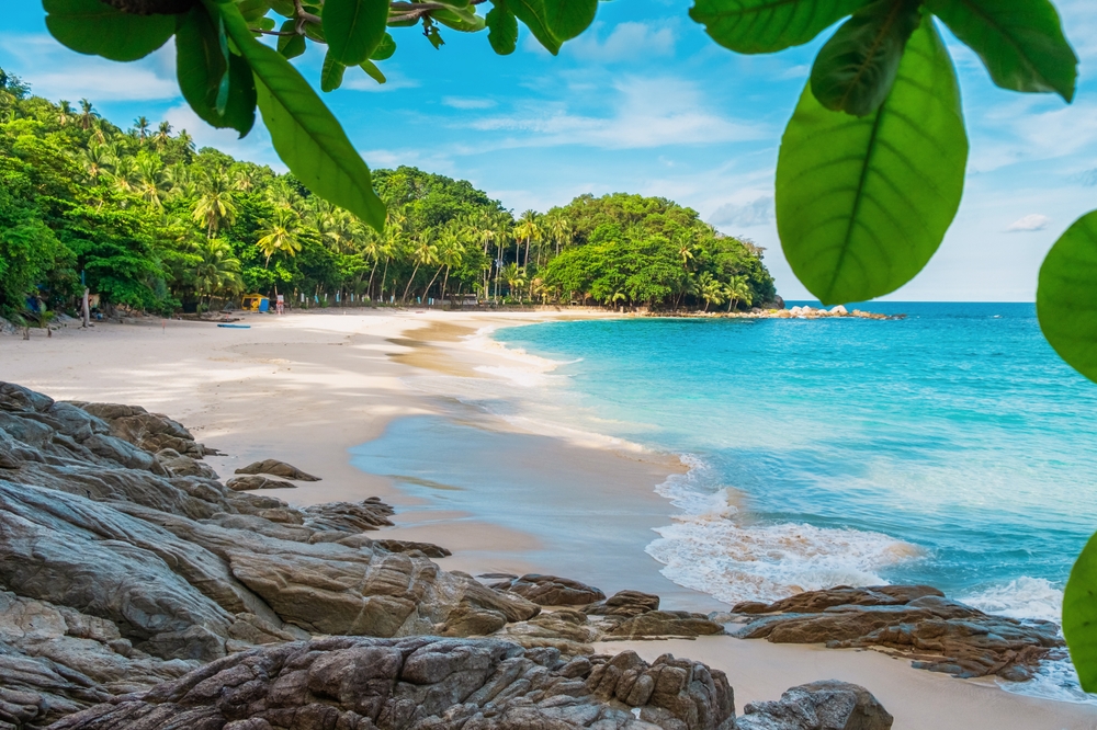 Freedom Beach med palmer og turkist vann på Phuket