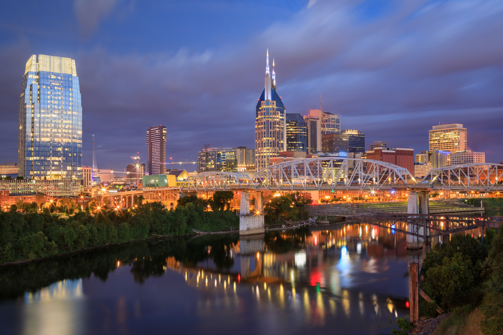 Nashvilles silhuett og gangbroen John Seigenthaler Pedestrian Bridge over Cumberland River ved daggry