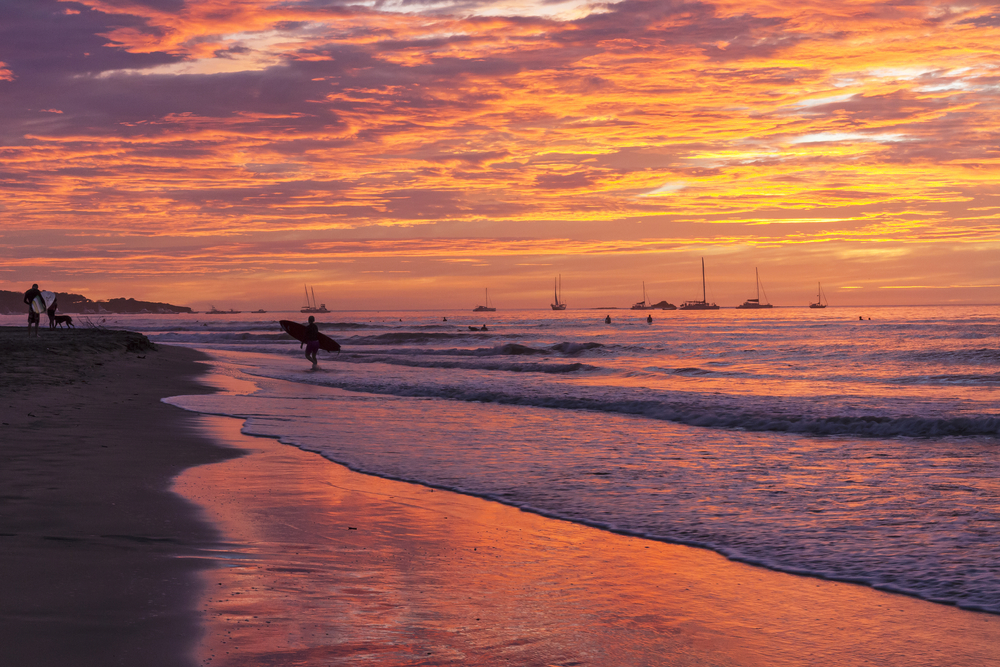 Surfer på stranden i Tamarindo i Guanacaste i solnedgang