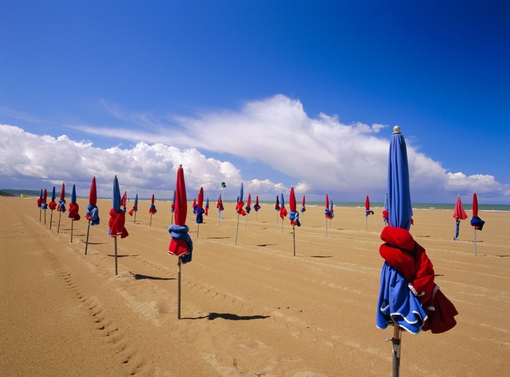 De fargerike parasollene på stranden i Deauville i Normandie