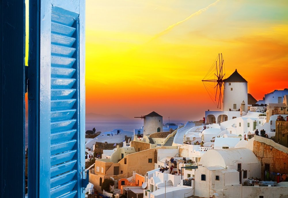 gyllen solnedgang i Oia med vindmølle