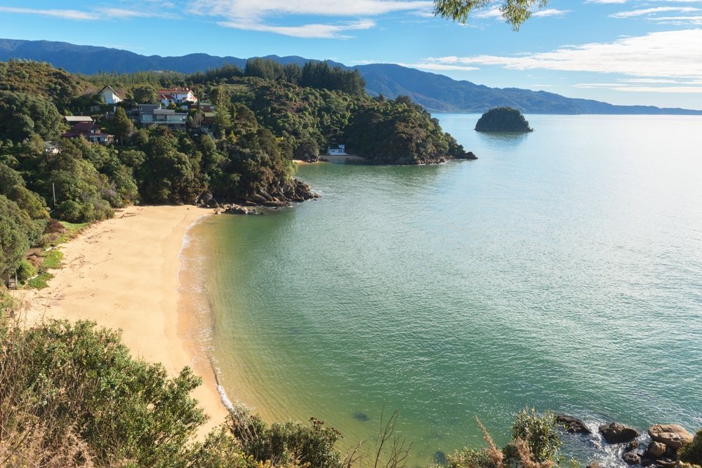 Gyllen strand og turkis vann ved Kaiteriteri ved Abel Tasman nasjonalpark