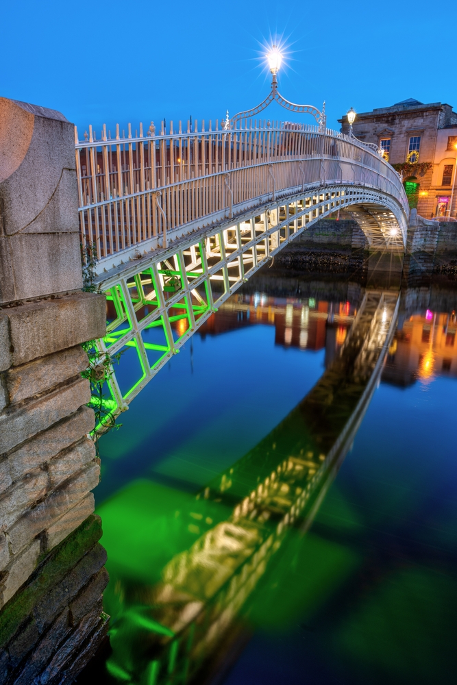 Ha'penny Bridge over elva Liffey i Dublin i skumringen