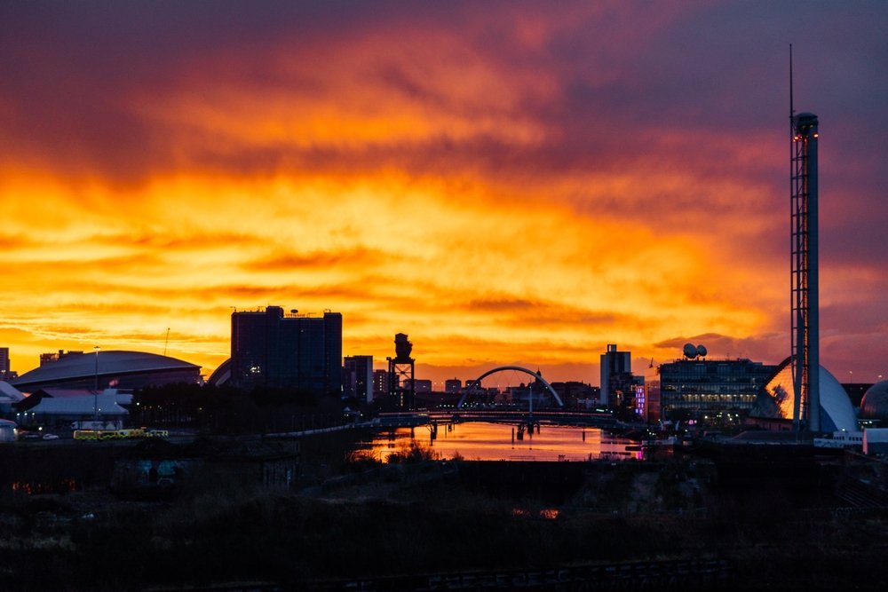 Glasgows skyline ved solnedgang, sett over elven Clyde