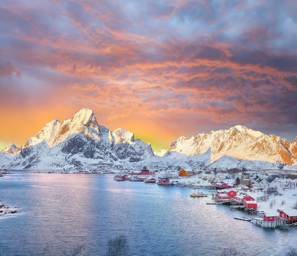 Hvor skal man bo i Norge: Reine på Lofoten med røde rorbuer under fjellene