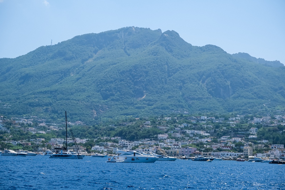 Fjellet Epomeo og en havneby på Ischia med ankrede båter i forgrunnen
