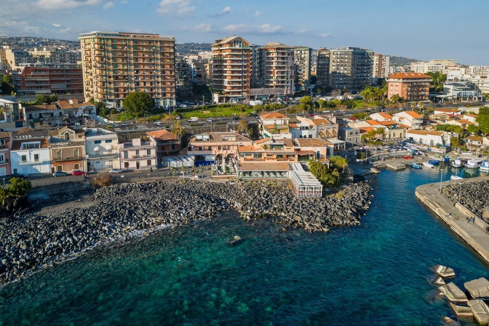 Den lille havnen og den svarte lavastranden ved San Giovanni li Cuti i Catania