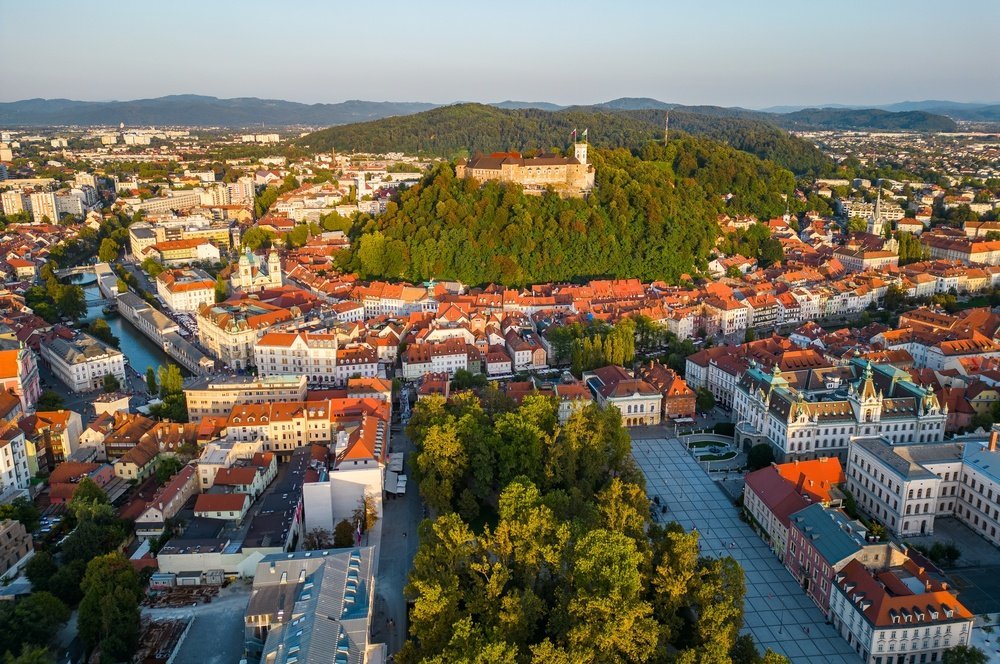 Hvor bør man bo i Slovenia? De 6 beste områdene & gode hoteller 2 Old Town i Ljubljana med slottet på bakken og elva Ljubljanica