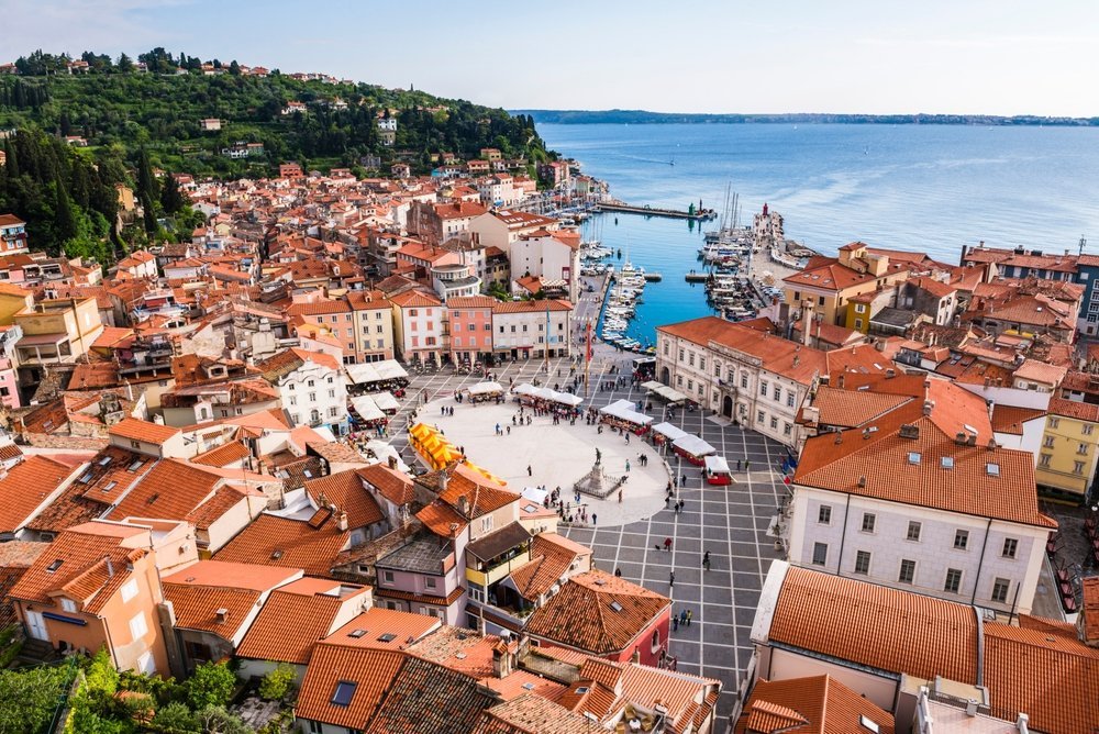 Hvor bør man bo i Slovenia? De 6 beste områdene & gode hoteller 6 Piran og Tartini-plassen sett fra klokketårnet ved St. Georgs kirke med Adriaterhavet i bakgrunnen