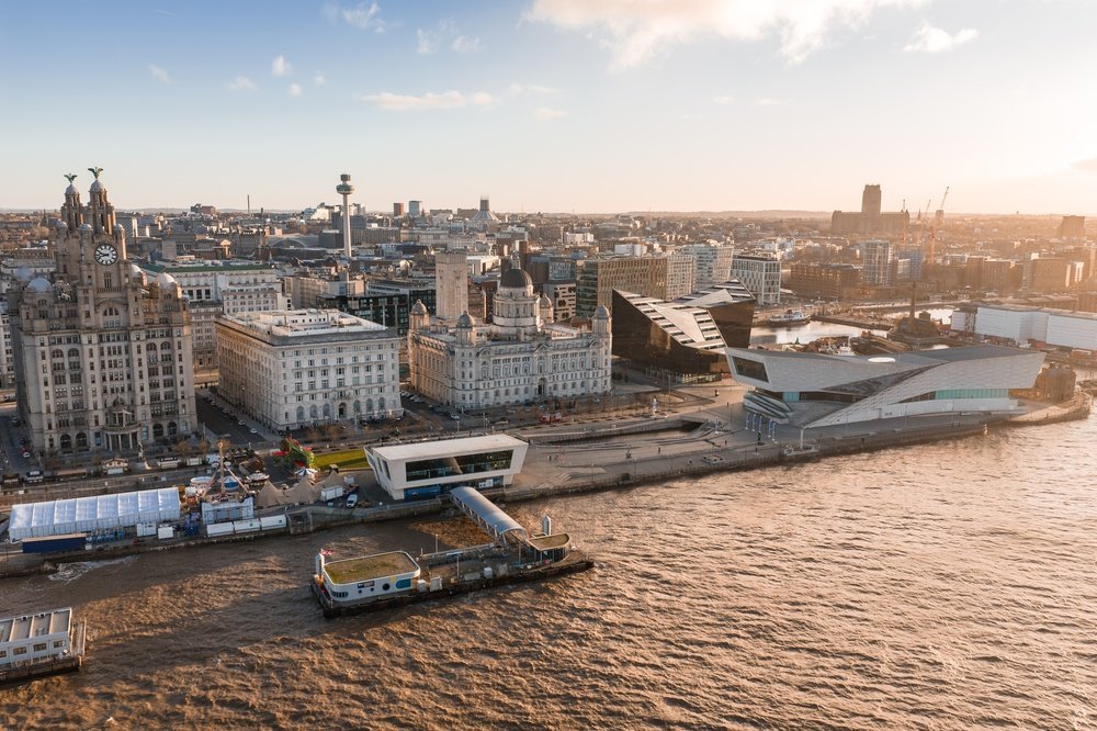 Liverpools havnefront med Three Graces og katedralen sett fra luften ved soloppgang