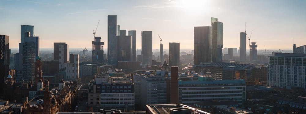 Manchesters sentrum sett fra luften med skyskrapere og røde murbygninger