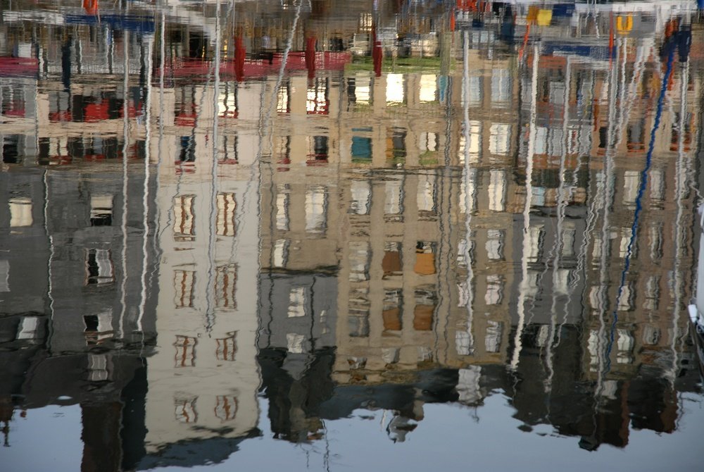 De smale husene rundt den gamle havnen Vieux Bassin i Honfleur speilet i vannet