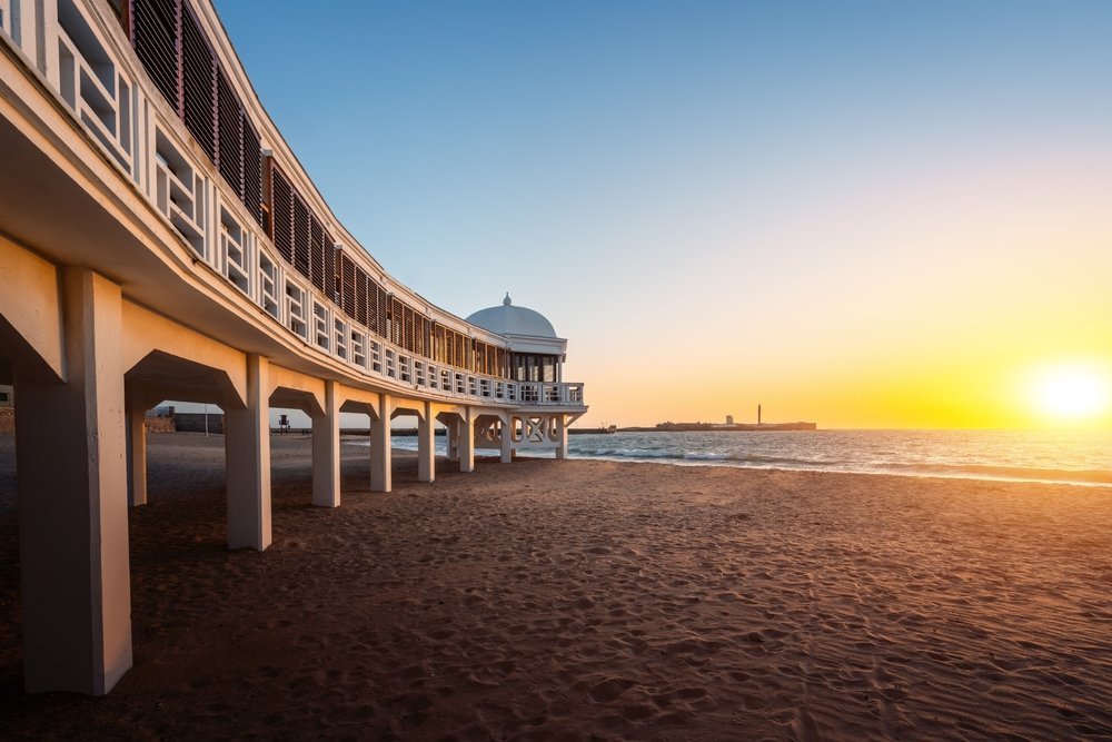 Stranden La Caleta i Cádiz med badehuset Balneario de la Palma i solnedgang
