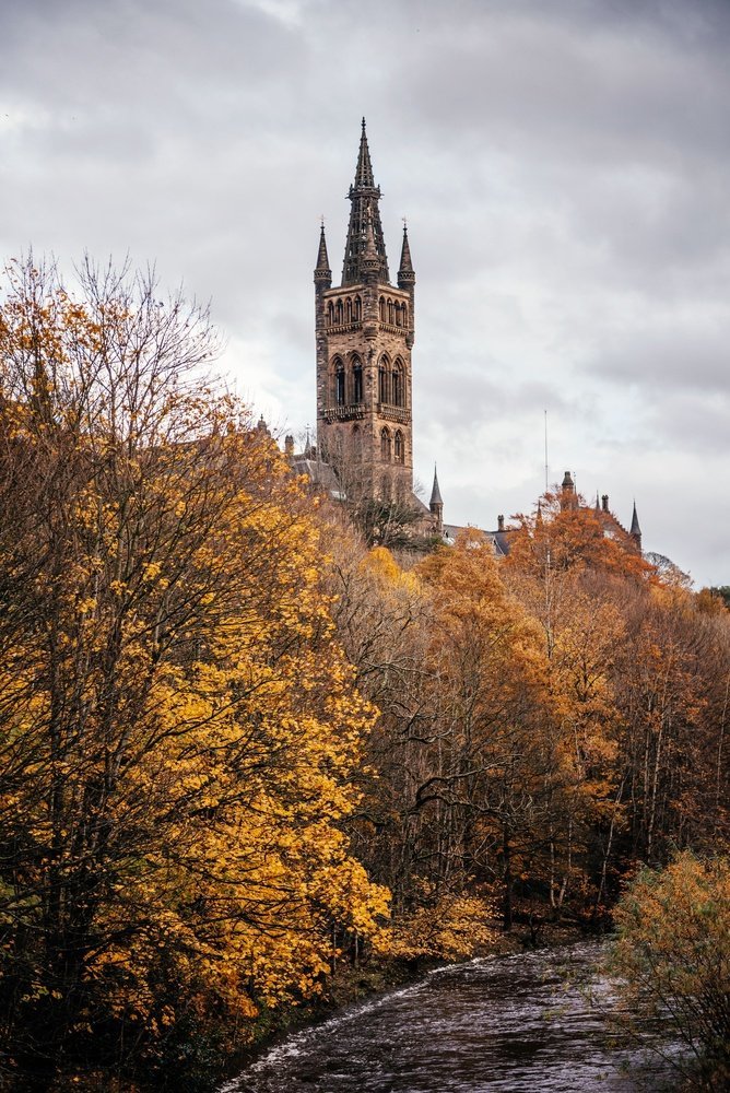 Tårnet på University of Glasgow over trærne ved elva Kelvin