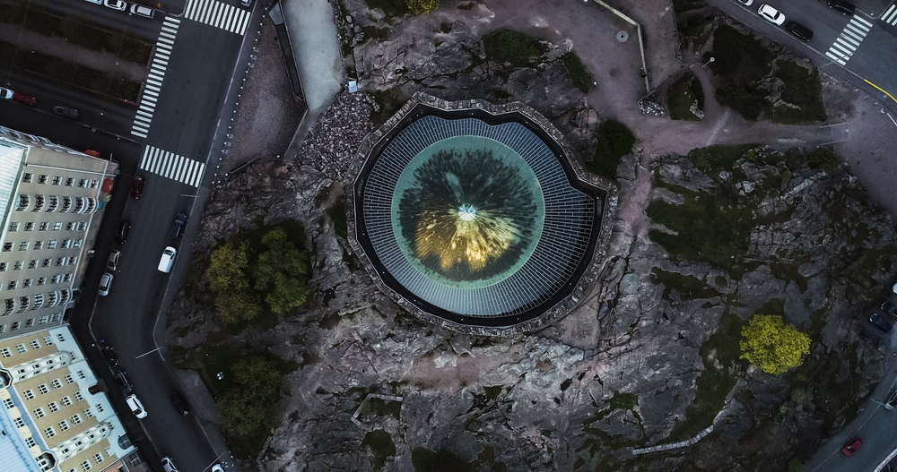 Hvor bør man bo i Helsinki? De 6 beste områdene & gode hoteller 7 Temppeliaukio-kirken i Töölö sett fra luften ved soloppgang